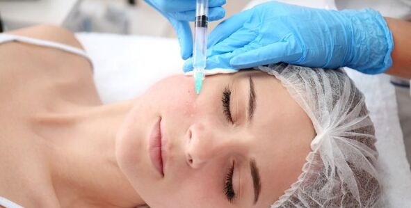 Une esthéticienne effectue un rajeunissement de la peau du visage à l'aide du plasma